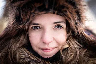 Portrait en gros plan d'une femme vêtue d'une capuche en fourrure en hiver, regardant vers la caméra