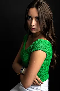 Jeune femme en tenue verte posant sérieusement