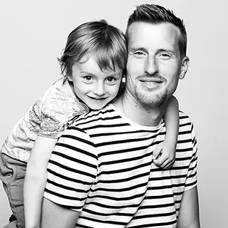 Père et enfant souriants en portrait noir et blanc