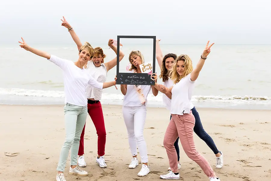 Groupe de filles posent sur la plage lors d'un enterrement de vie de jeune fille