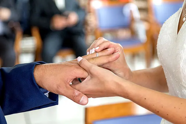 La mariée passe l'alliance au doigt de son mari à la mairie
