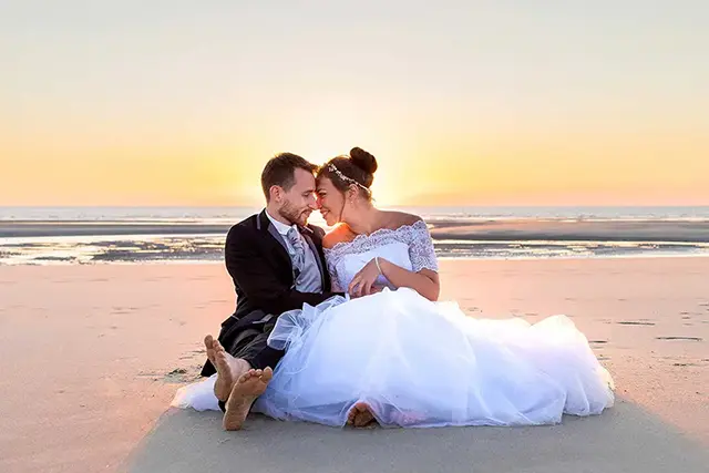 Jeunes mariés sur une plage au coucher du soleil
