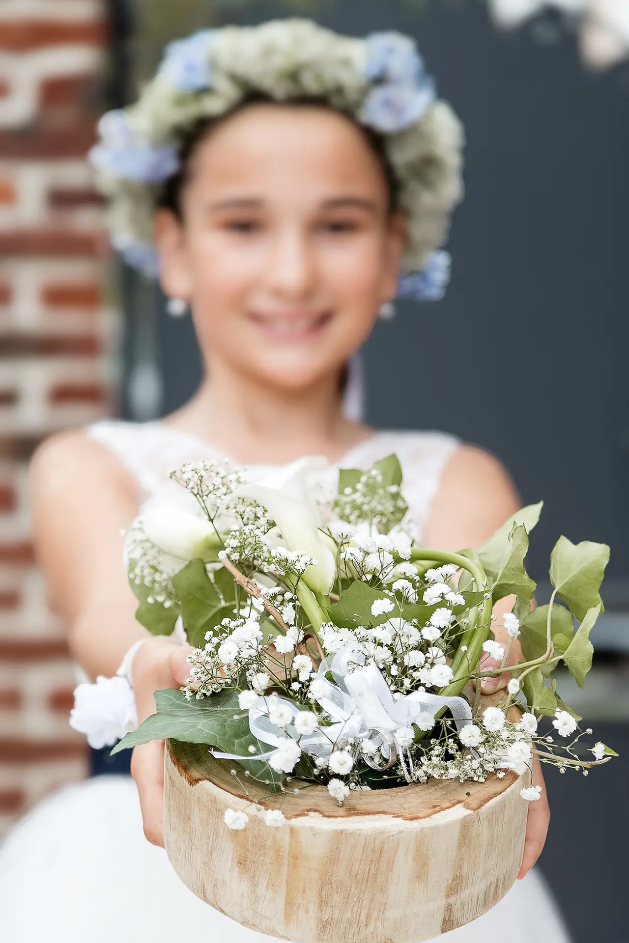 Enfant tendant un bouquet de mariÃ©e devant elle