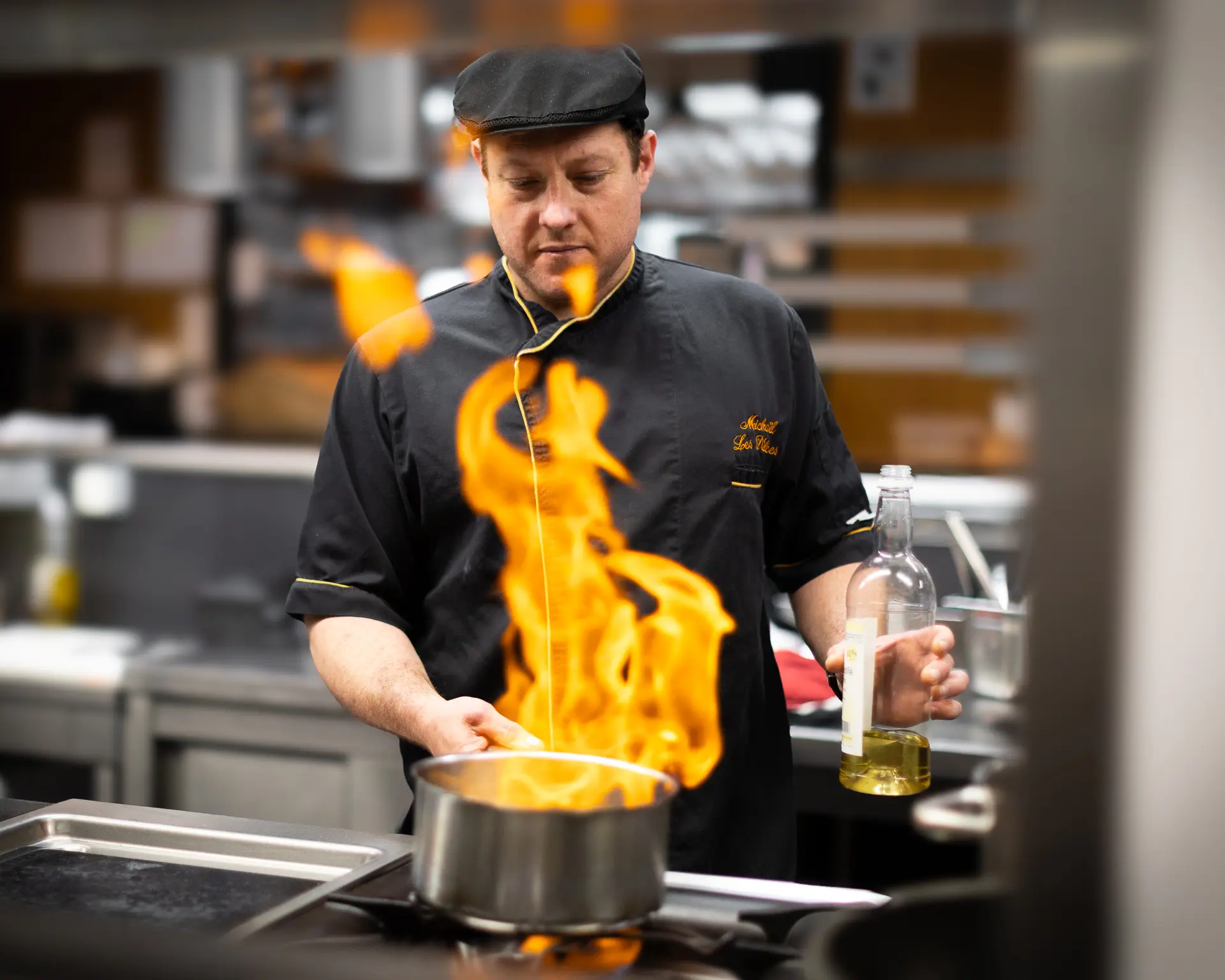 Chef cuisinier faisant flamber un plat dans les cuisines d'un restaurant