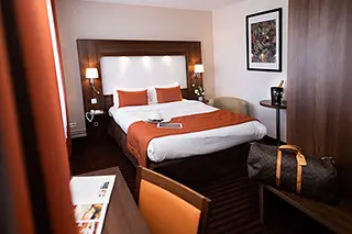 Chambre supérieure d'hôtel avec lit double, éclairage doux et décoration élégante