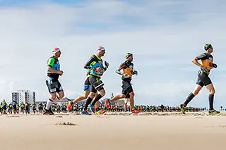 Coureurs participant à un marathon sur une plage